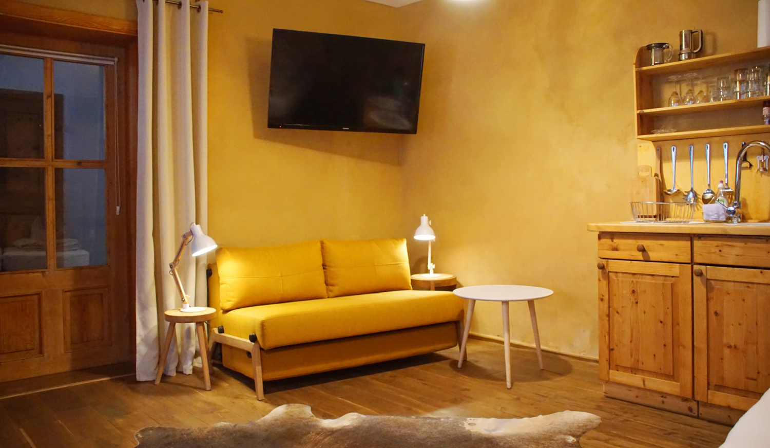 Sitzecke mit Schlafcouch und Fernseher.jpg