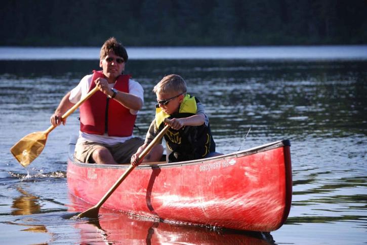father-and-son-paddle-a-canoe-on-river-725x485.jpg