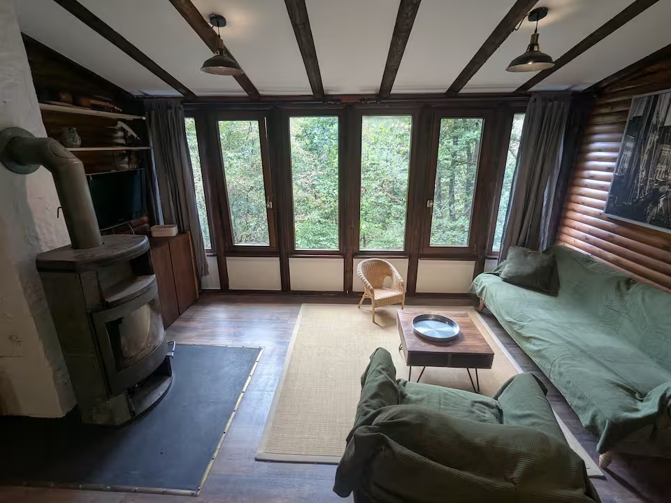 Wohnzimmer mit großen Fenstern und Blick ins Grüne