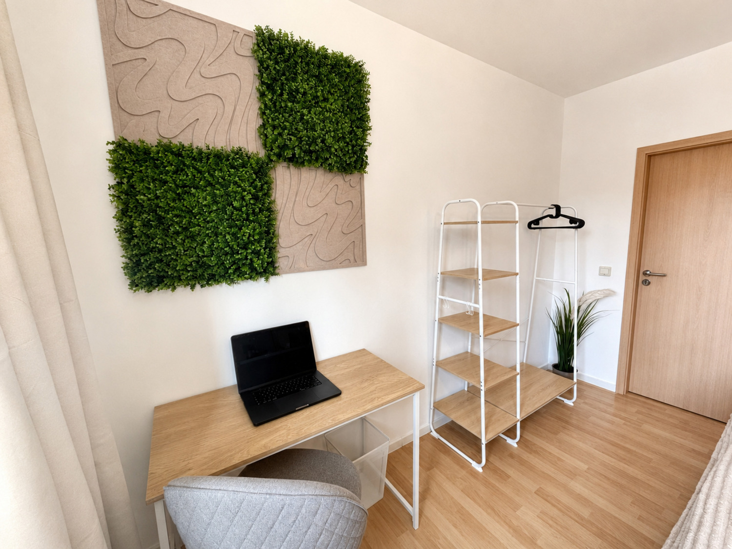 Schreibtisch mit grüner Wanddekoration in der Ferienwohnung Naturkraft
