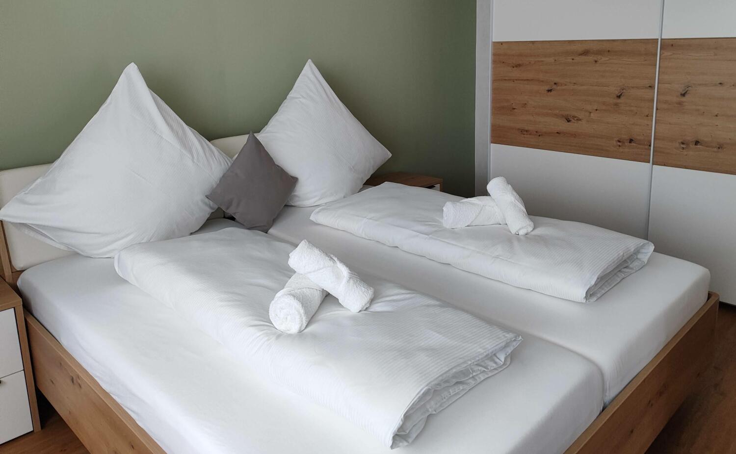 Doppelbett mit frischer Bettwäsche im Schlafzimmer des Apartment Marissa in Billerbeck